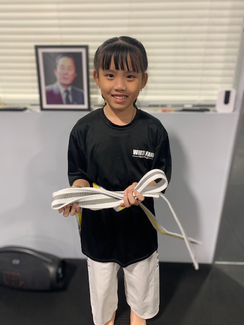 Young student holding a new white belt