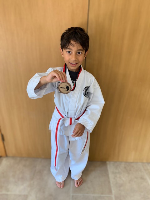 Young Taekwon-Do student posing after class