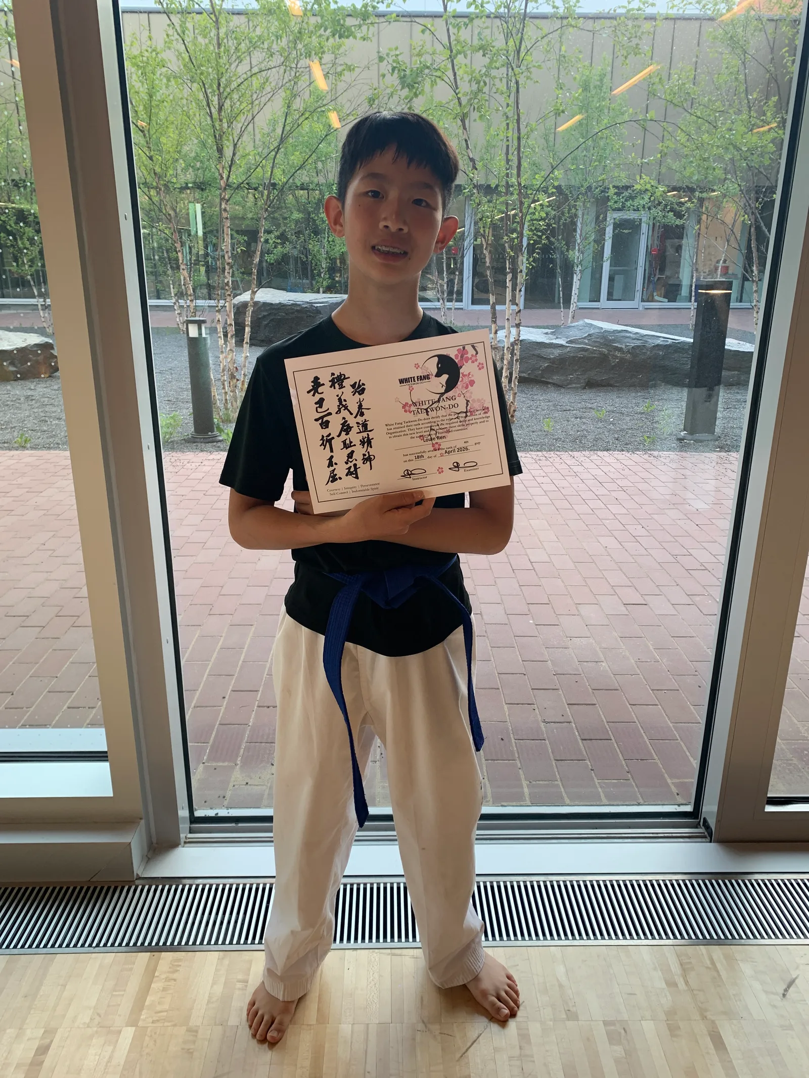 King City Taekwon-Do student Louie holding his promotion certificate