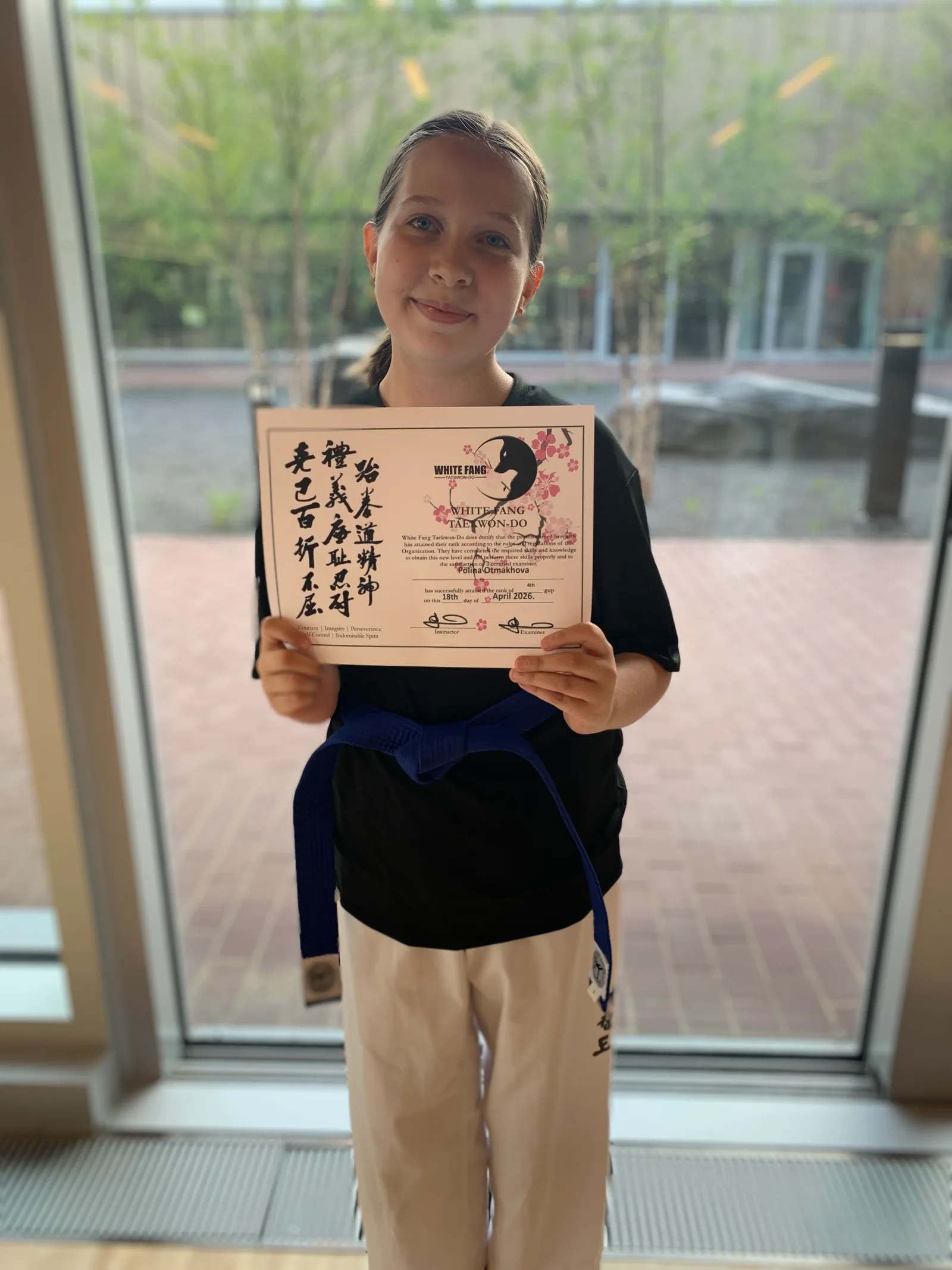 King City Taekwon-Do student Polina holding her promotion certificate