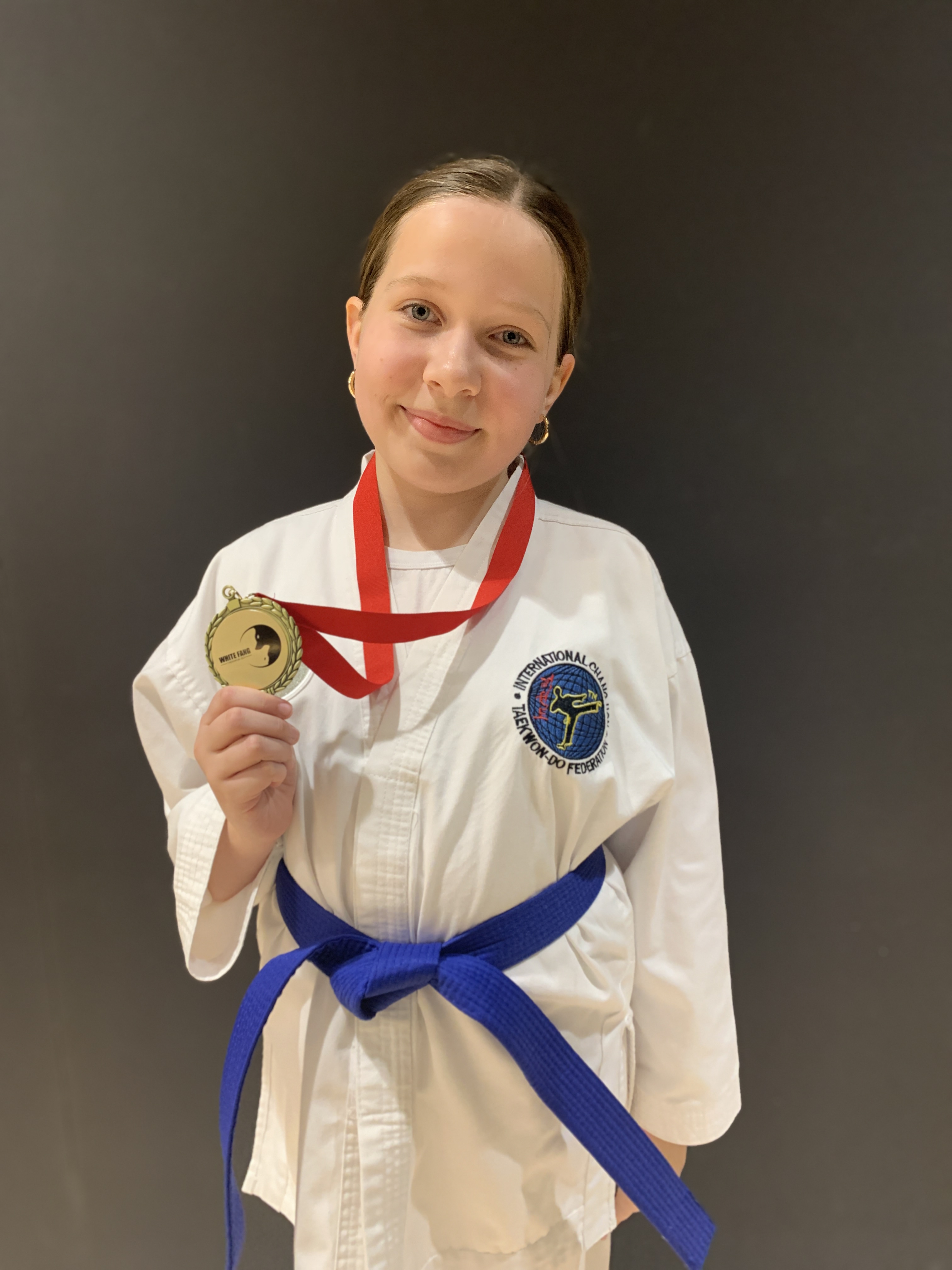 Youth student displaying a Taekwon-Do medal