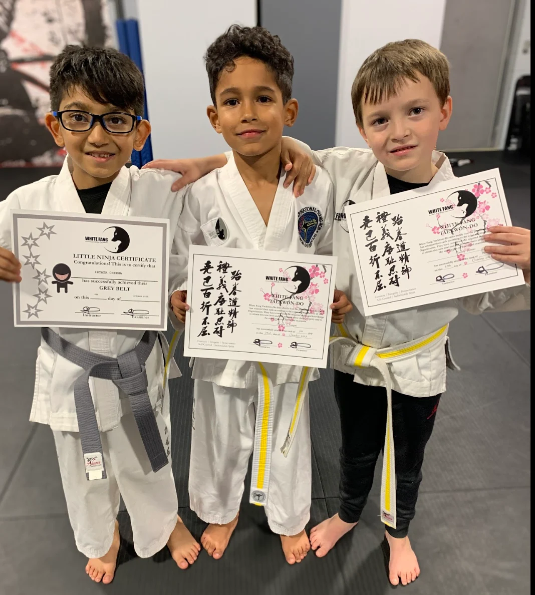 Kids martial arts students holding promotion certificates in Woodbridge