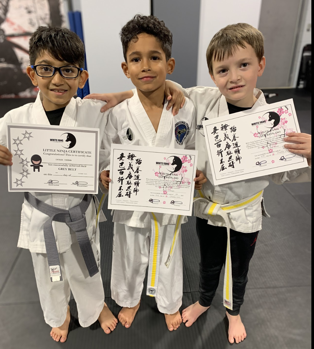 Kids martial arts students holding promotion certificates in Woodbridge