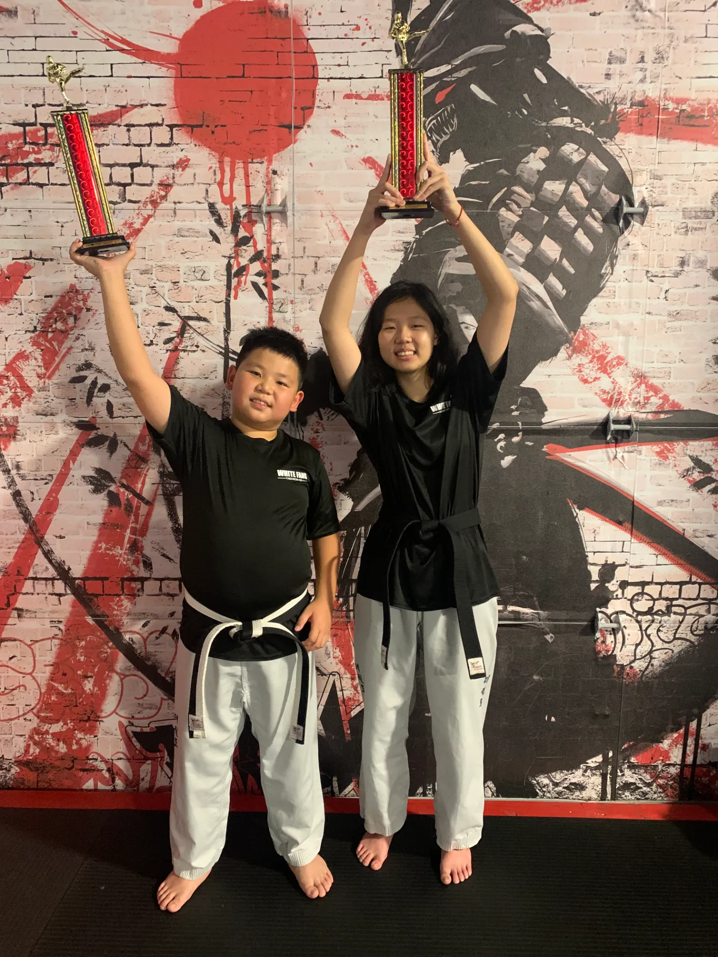 Lin family students proudly raising their trophies in Woodbridge