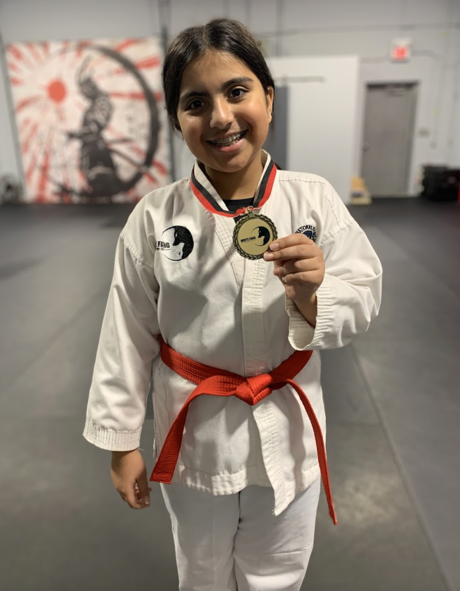 Taekwon-Do student proudly holding a medal